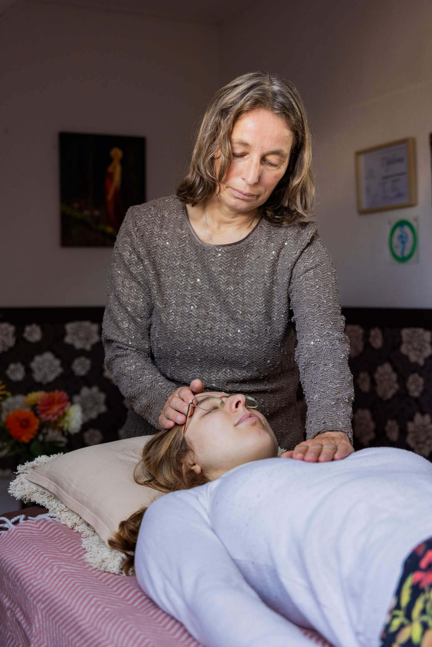 Hinke legt handen op het hoofd en hart van de client op de behandeltafel. Praktijk voor Healing Touch